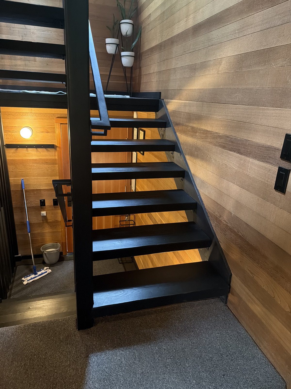 Staircase with wood-paneled walls and clean carpeting