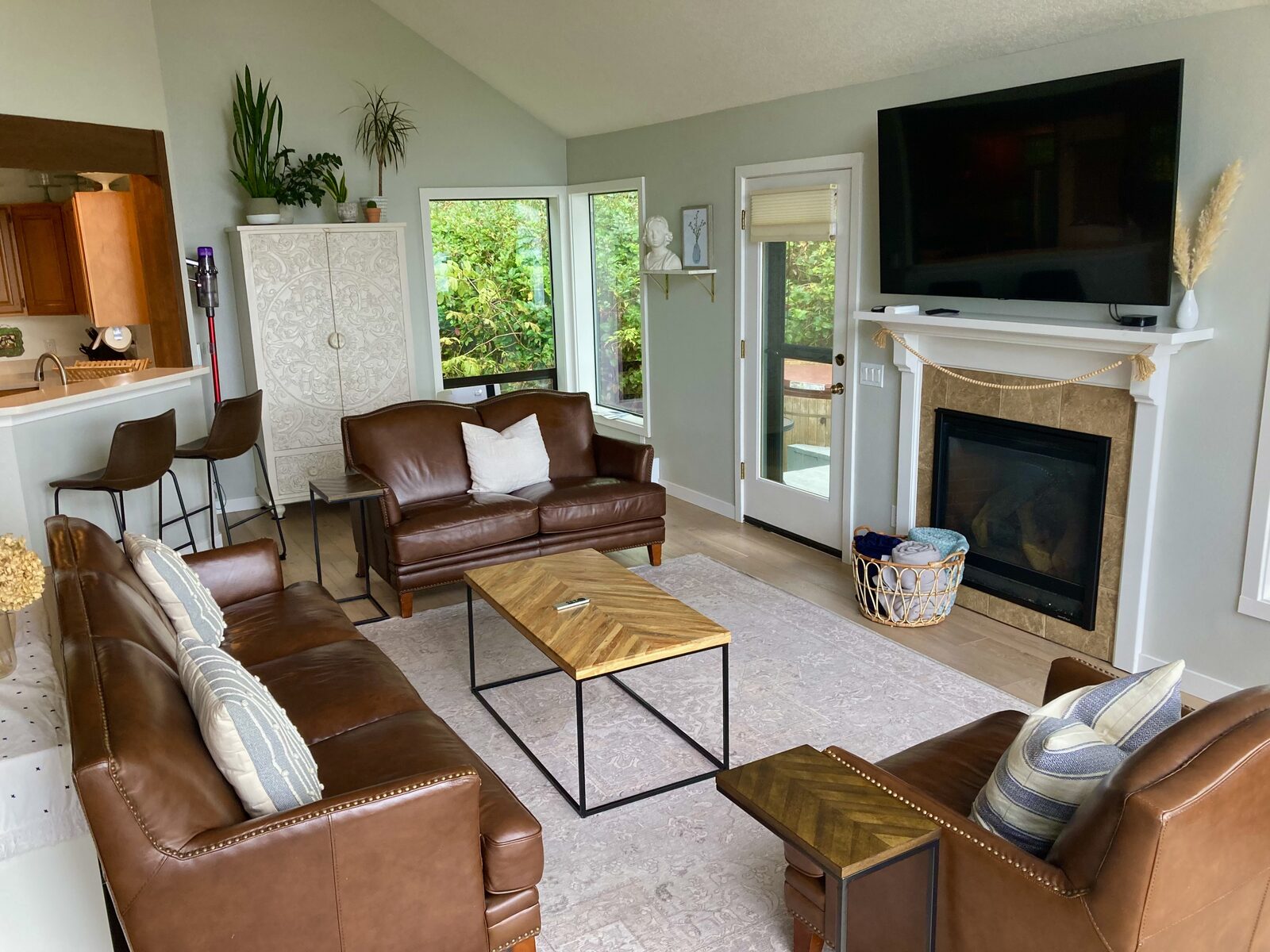 Spotless coastal living room with leather sofas, fireplace and open kitchen after cleaning